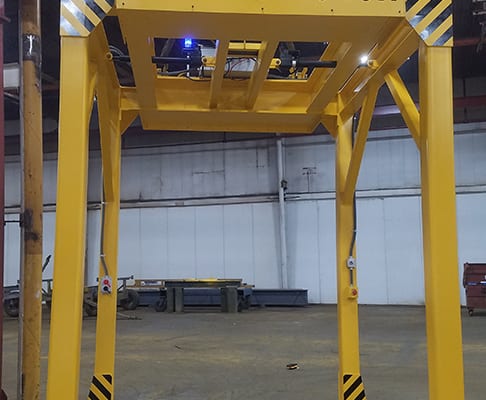 A 9-ton safety yellow below-the-hook lifting device designed, manufactured, and installed by CraneWerks, Inc. for a Columbus, Indiana company that makes diesel engines for commercial vehicles.