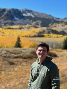 Conner Davis of CraneWerks pictured on a hike in the mountains in his military green CraneWerks hoodie