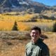 Conner Davis of CraneWerks pictured on a hike in the mountains in his military green CraneWerks hoodie