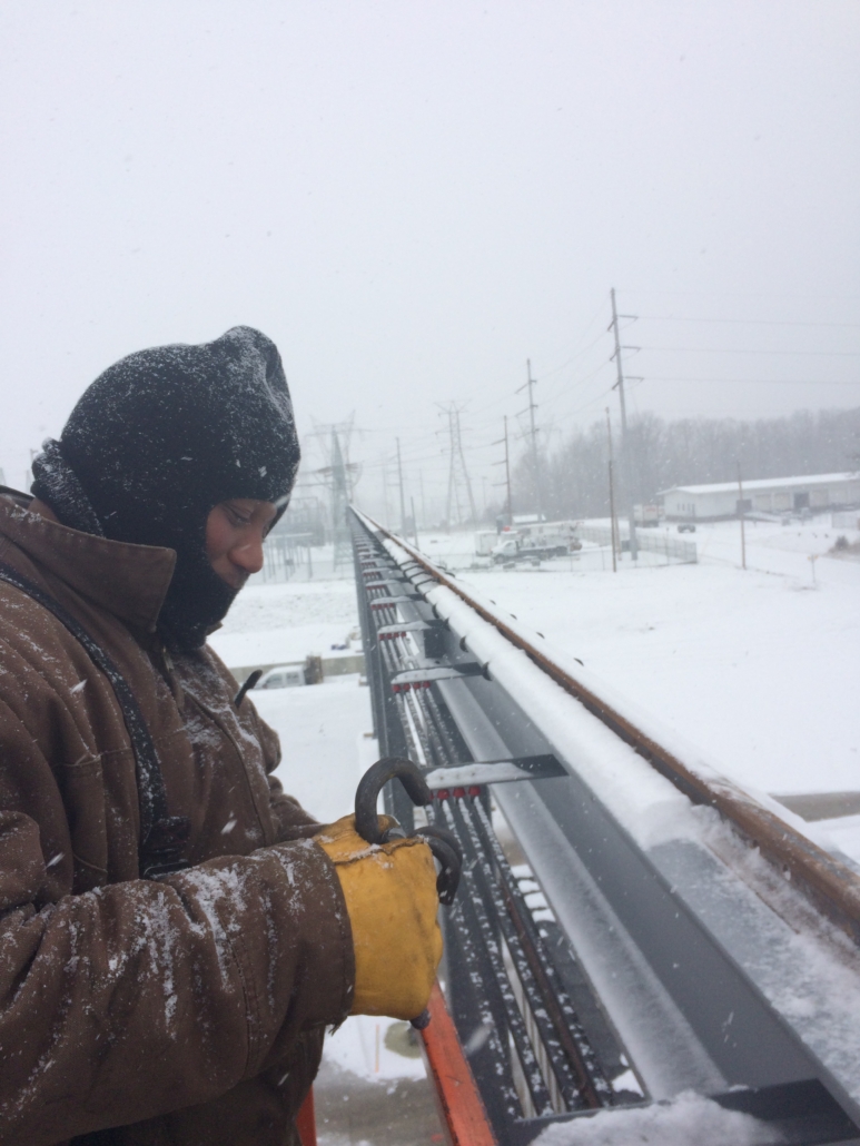 CraneWerks technician servicing outdoor equipment in the winter